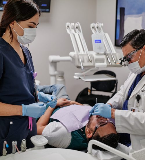 Healthcare_senior_dentist_and_assistant_working_on_a_patient_s_teeth_-IOperp_BOBO-__1_